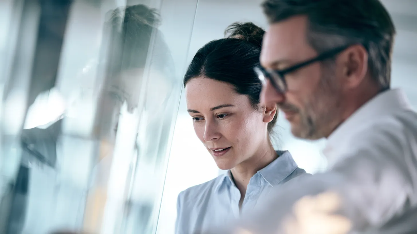 Two colleagues discussing a project in a bright modern office